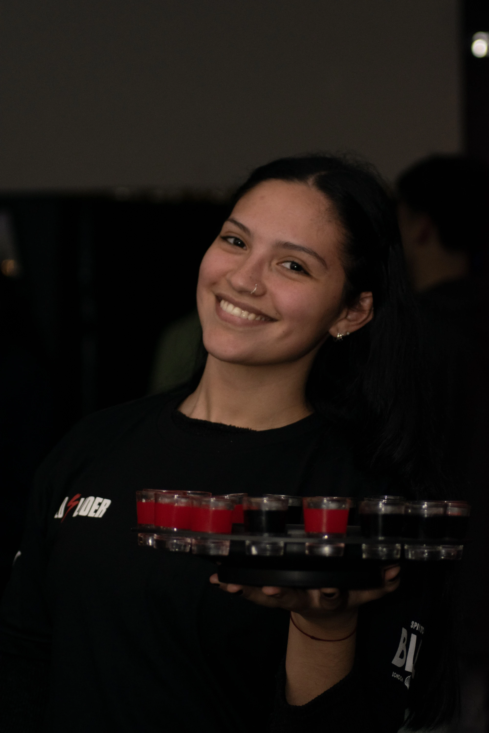 Moza sonriendo con una bandeja de shots en Cristobal Bar